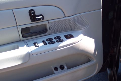 2001 Ford Crown Victoria - Close-up of the interior door panel, showing the power window and seat controls.
