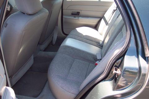 2001 Ford Crown Victoria - Rear interior view of a sedan, showing gray fabric seats and door panels.