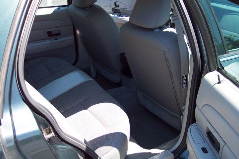 2001 Ford Crown Victoria - The interior of a Ford Crown Victoria shows the rear seating area and door panel details.