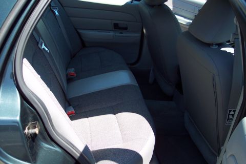2001 Ford Crown Victoria - Rear interior view of a dark green vehicle, showing the back seats and seatbelts.