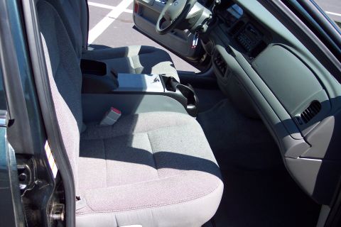 2001 Ford Crown Victoria - The interior of a 2001 Ford Crown Victoria is visible from the passenger side, showing the front seats and dashboard.