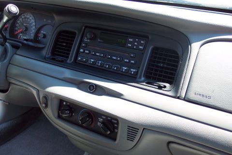2001 Ford Crown Victoria - Interior view of a vehicle's dashboard, showing the radio, climate controls, and an airbag warning label.