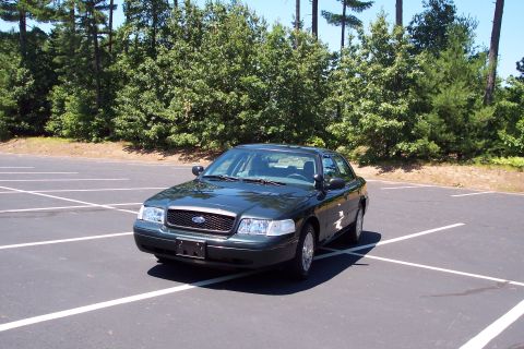 2001 Ford Crown Victoria - Dark green 2001 Ford Crown Victoria parked in a lot on a sunny day.