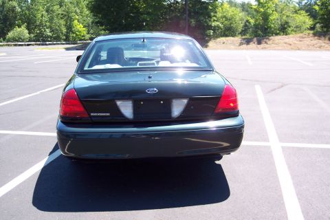 2001 Ford Crown Victoria - Rear view of a dark green 2001 Ford Crown Victoria, showing the Police Interceptor badge.
