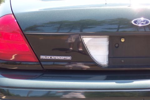 2001 Ford Crown Victoria - The rear of a Ford Police Interceptor shows the 'POLICE INTERCEPTOR' badge and the Ford emblem.