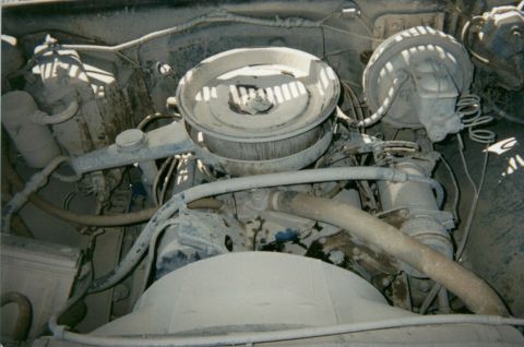 1977 Chevrolet C/K Pickup - Close-up view of a dusty engine bay, showing the air cleaner assembly and brake booster.
