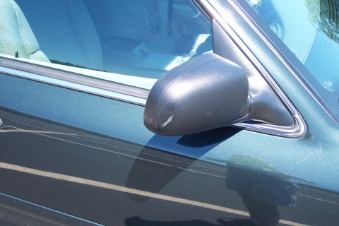 2001 Ford Crown Victoria - Close-up of a 2001 Ford Crown Victoria's side mirror and door, showing a scratch on the mirror housing.