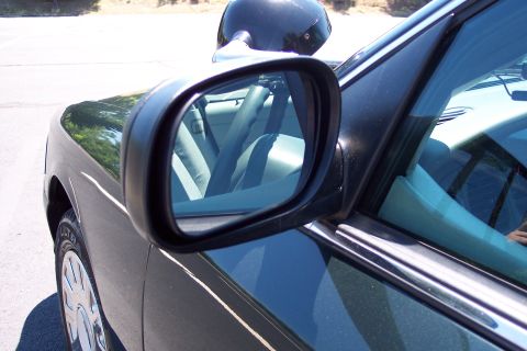 2001 Ford Crown Victoria - Side mirror view of the interior of a dark green 2001 Ford Crown Victoria.