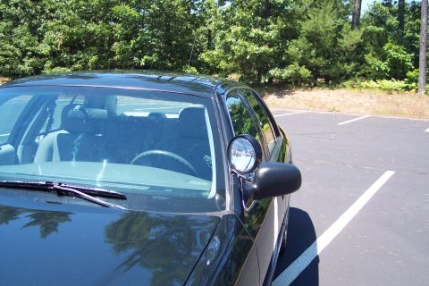2001 Ford Crown Victoria - A black police car is parked in a lot, showing its side profile and interior details.