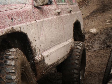 1998 Jeep Cherokee - This vehicle is heavily covered in mud, indicating it has been driven off-road.