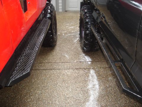 1989 Ford Bronco - Two vehicles parked side-by-side on a wet driveway.