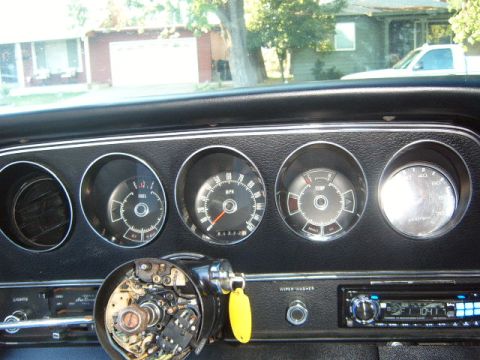 1973 Ford Ranchero - The interior of a vehicle shows a dashboard with multiple gauges and an exposed steering column.