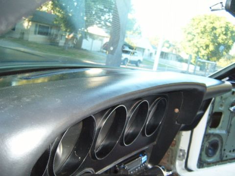 1973 Ford Ranchero - View from inside a vehicle, looking out the windshield at houses and another vehicle.