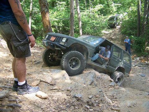 1992 Jeep YJ - A modified Jeep Cherokee XJ navigates a challenging off-road trail with another Jeep in the background.
