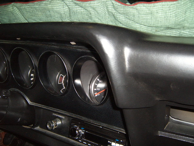 Black dashboard interior with four circular gauges, a radio, and a "SUPER-WASH" label