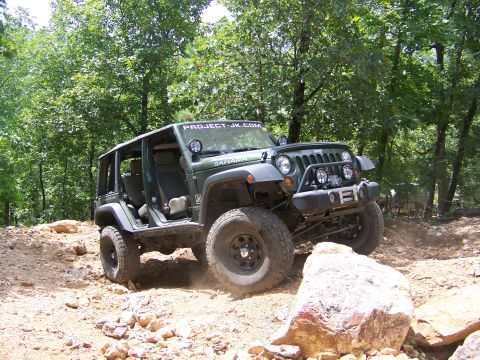 1992 Jeep YJ - This Jeep Wrangler is navigating a rocky, wooded trail with its doors removed.