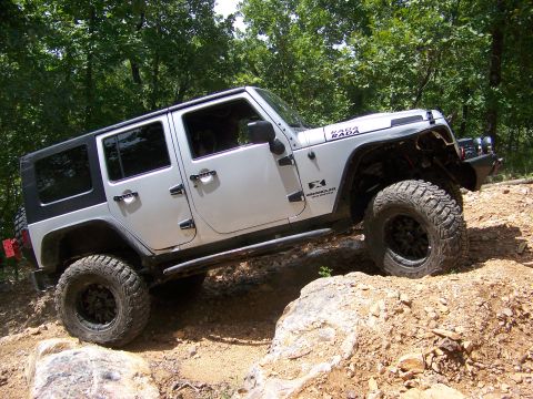 1992 Jeep YJ - Silver Jeep Wrangler navigates a rocky trail, with "RADA RADA" visible on the hood.