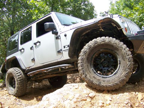 1992 Jeep YJ - This Jeep Wrangler is navigating a challenging off-road trail with steep inclines and loose terrain.