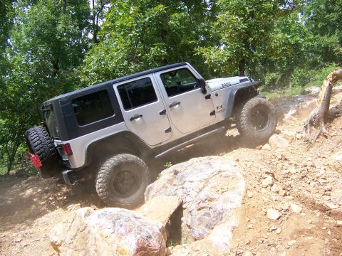1992 Jeep YJ - Silver Jeep Wrangler navigates a challenging rocky off-road course.