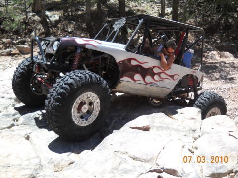 1987 Suzuki Samurai - A heavily modified off-road buggy navigates a rocky trail.