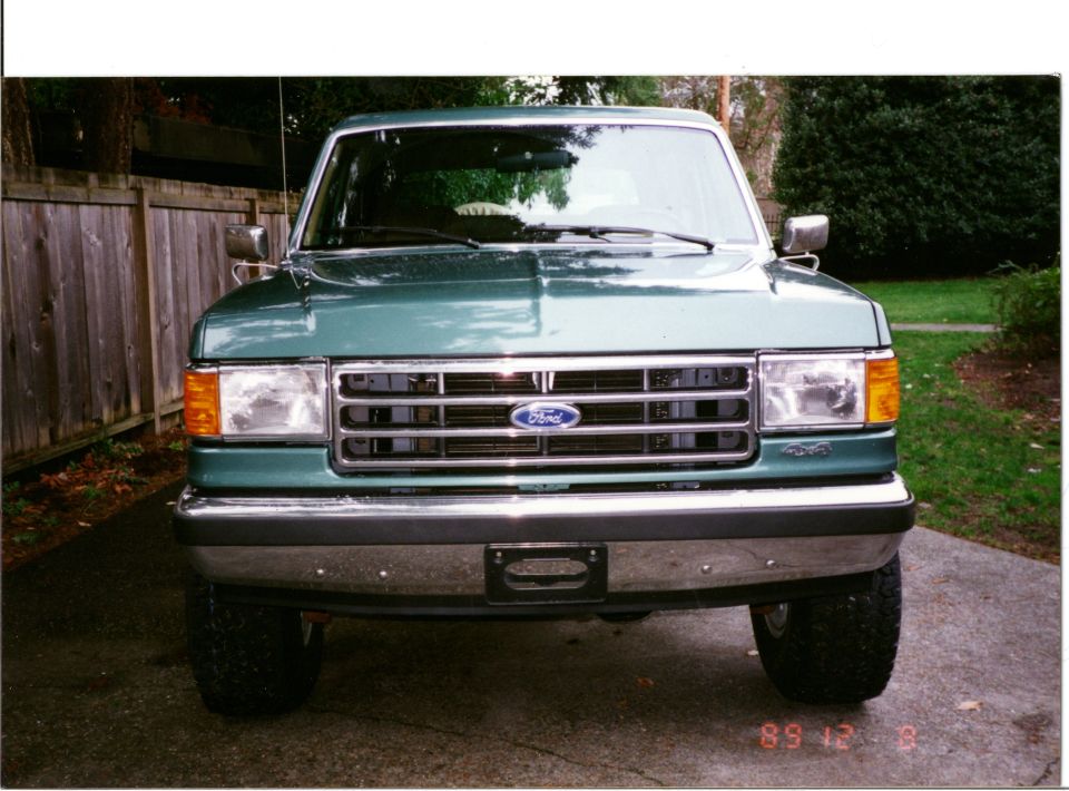Green Ford F-Series truck front view, parked on driveway