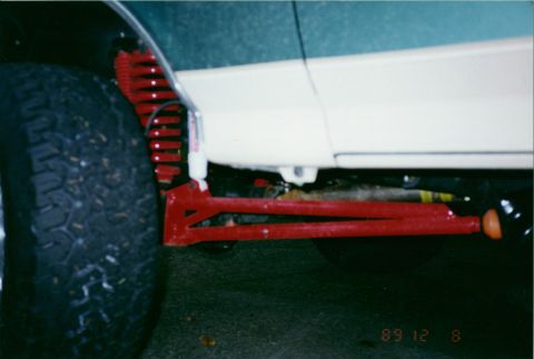 1990 Ford Bronco - Close-up view of red suspension parts and a tire on a vehicle. The date stamp reads 89 12 8.