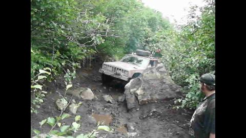 1998 Jeep Cherokee - This Jeep Cherokee is navigating a difficult off-road course, getting stuck on a large rock formation.