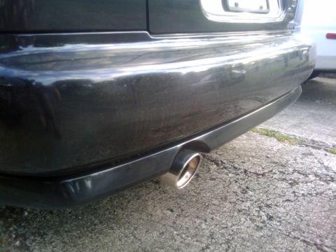 1998 Subaru Legacy - The chrome exhaust pipe is visible on the rear of a dark-colored vehicle.