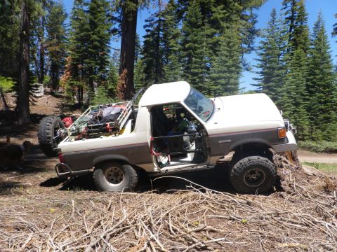 1991 Ford Bronco - This Ford Bronco appears to be from the late 1980s, possibly a 1987 model, and is navigating a challenging off-road terrain.