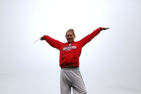 1990 Chevrolet Suburban - A young woman stands with her arms spread wide against a bright, overcast sky.