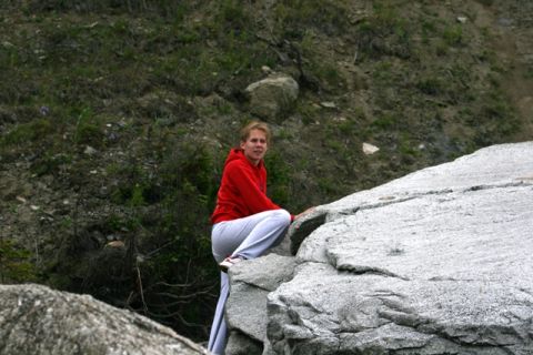 1990 Chevrolet Suburban - A woman in a red hoodie and grey pants ascends a rocky incline.