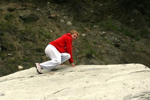 1990 Chevrolet Suburban - A person is shown in a crouched position, appearing to climb a large rock formation.