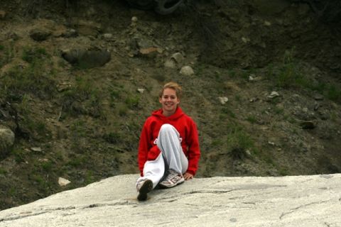 1990 Chevrolet Suburban - A person is sitting on a large rock, smiling at the camera with a natural, rocky landscape in the background.
