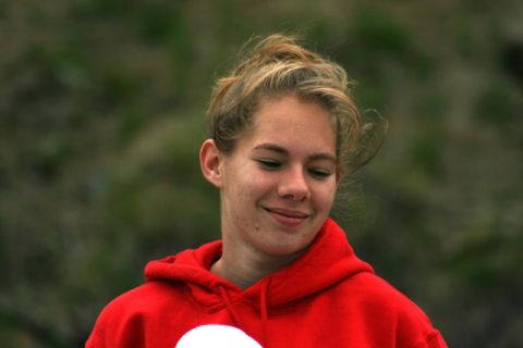 1990 Chevrolet Suburban - A young woman with her hair up smiles slightly while wearing a red hoodie.