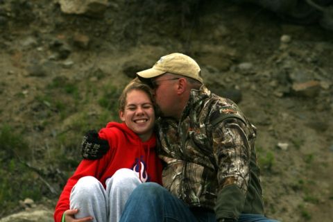 1990 Chevrolet Suburban - A father shares a tender moment with his daughter, embracing her with a kiss on the cheek.