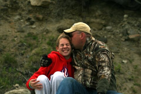 1990 Chevrolet Suburban - A father shares a tender moment with his daughter while sitting outdoors.