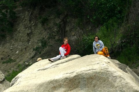 1990 Chevrolet Suburban - Two young women relax on a large boulder in a natural outdoor setting.