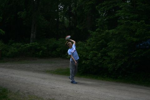 1990 Chevrolet Suburban - A person prepares to throw a football in a park setting with trees in the background.