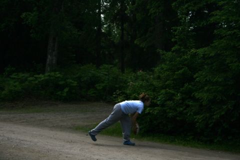 1990 Chevrolet Suburban - A person prepares to throw a ball in a wooded area.