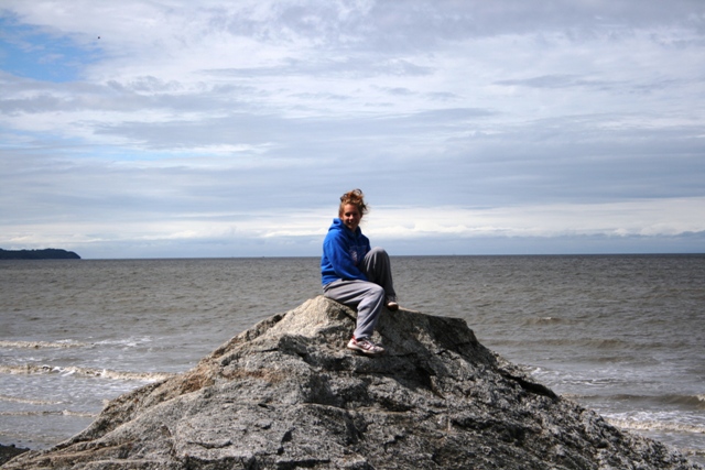 Person sitting on a rock by the water