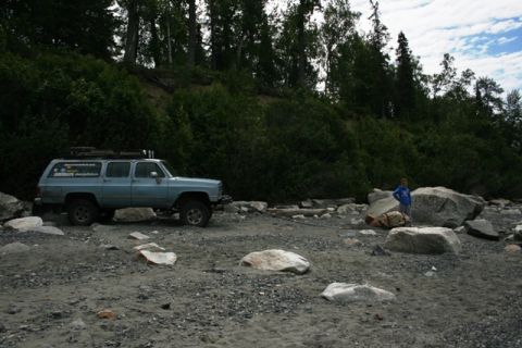 1990 Chevrolet Suburban - Light blue 1990 Chevrolet Suburban parked on a rocky beach with a person standing nearby.
