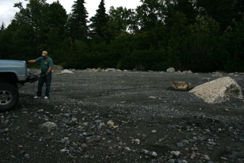 1990 Chevrolet Suburban - A man stands by a light blue 1990 Chevrolet Suburban on a rocky shore.