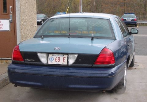 1998 Ford Crown Victoria - A Massachusetts police car is parked next to a building, with another police car visible in the background.