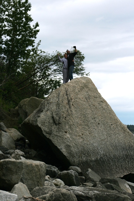 1990 Chevrolet Suburban - A couple takes a selfie while standing atop a large boulder near a wooded area.