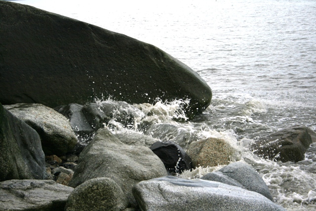 Waves crashing on a rocky shore with large boulders