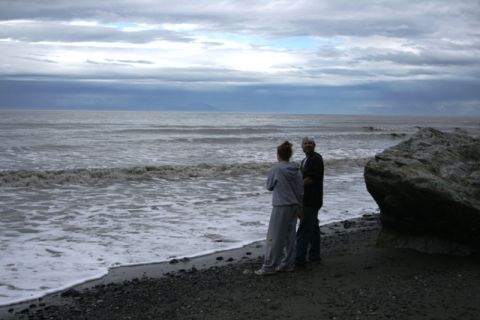 1990 Chevrolet Suburban - A couple contemplates the vast ocean from a rocky shore on an overcast day.