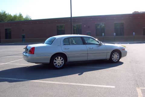 2001 Ford Crown Victoria - A silver 2004 Lincoln Town Car is seen from the side in a parking lot.