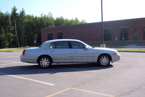 2001 Ford Crown Victoria - Side view of a silver Lincoln Town Car parked in a lot during the day.