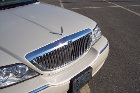 2001 Ford Crown Victoria - The front end of a Lincoln Town Car, its distinctive grille and hood ornament, is shown parked on asphalt.