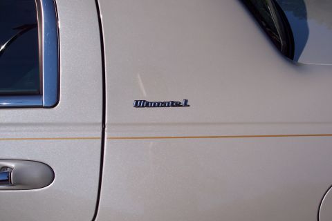 2001 Ford Crown Victoria - Close-up of a silver car door the 'Ultimate L' badging and a subtle pinstripe accent.